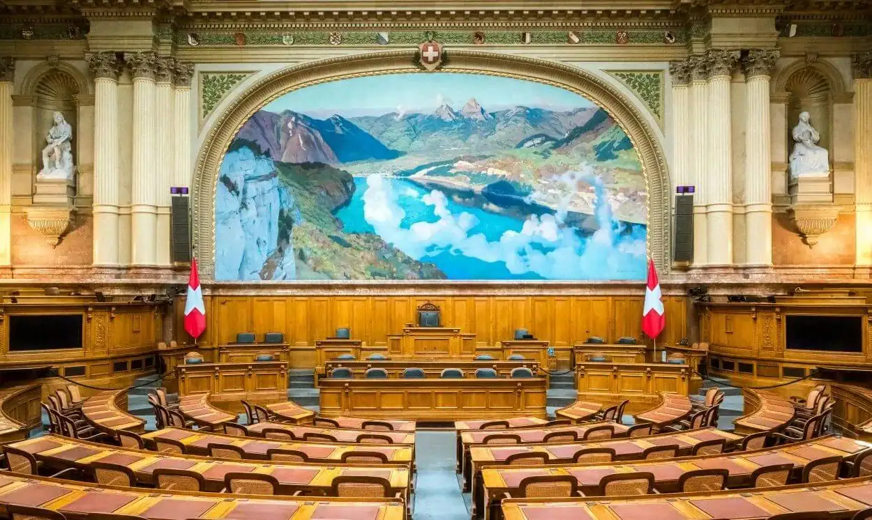 Conference hall with a large digital screen displaying a mountain landscape.
