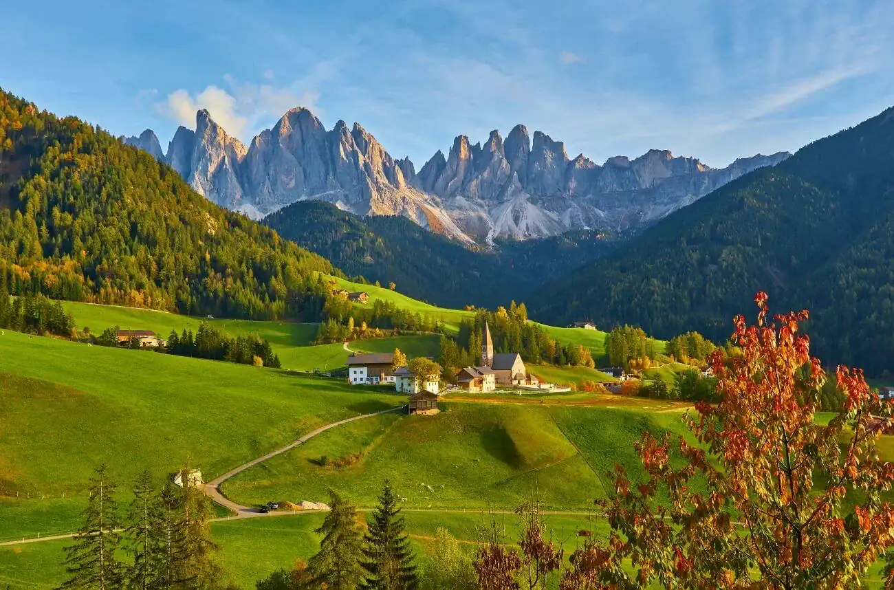 Beautiful mountain village surrounded by lush green hills and towering peaks.