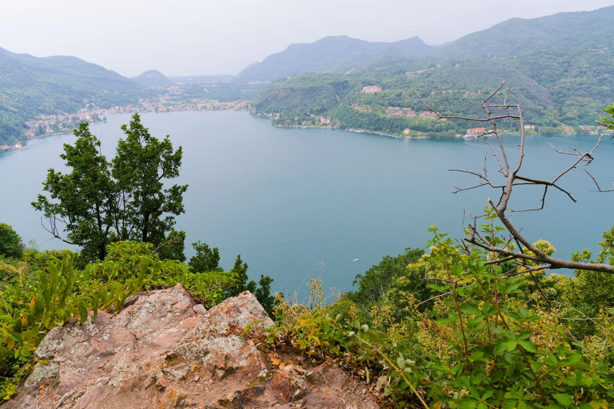 Explore the breathtaking view of Lake Lugano surrounded by lush greenery and mountains from Morcote.