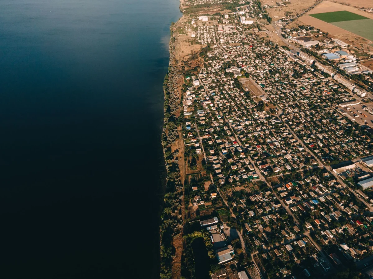 Veduta aerea di una cittadina costiera accanto all'oceano, che mette in mostra architettura urbana e natura.
