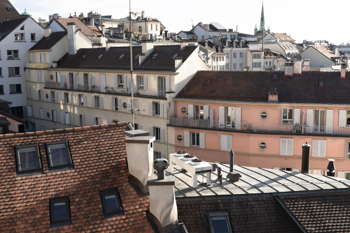 Charming view of residential rooftops and buildings in a European city, showcasing urban architecture.