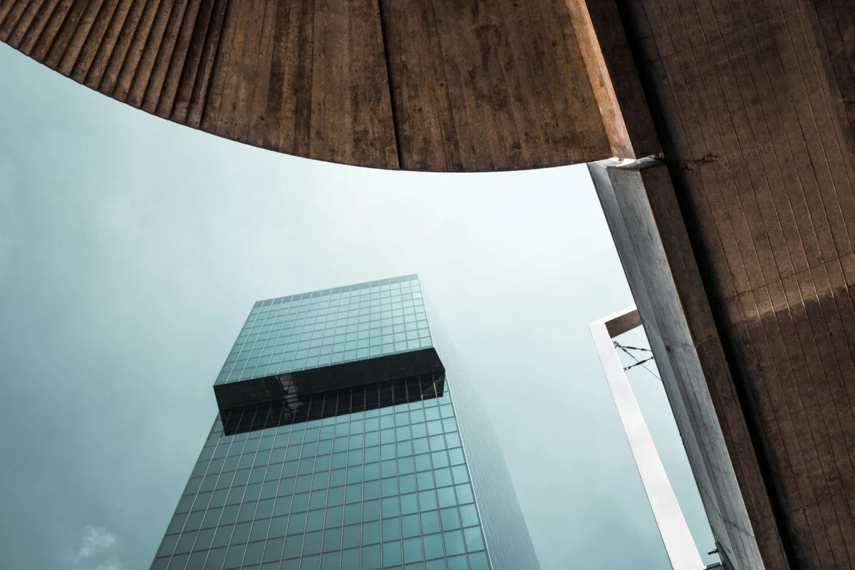 Un moderno grattacielo di vetro contro un cielo nuvoloso a Zurigo, che mette in mostra l'architettura urbana contemporanea.